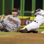 Arizona Diamondbacks' Chris Owings, left, reacts after the umpire called Miami Marlins runner Ichiro Suzuki, right, safe stealing to second during the 13th inning of a baseball game in Miami, Monday, May 18, 2015. After a review, Ichiro was called out. The Diamondbacks won 3-2 in the 13th inning. (AP Photo/J Pat Carter)