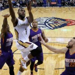 New Orleans Pelicans forward Tyreke Evans (1) drives to the basket past Phoenix Suns guard Eric Bledsoe, left, forward P.J. Tucker, center, and center Miles Plumlee, right, during the first half of an NBA basketball game, Tuesday, Dec. 30, 2014, in New Orleans. (AP Photo/Jonathan Bachman)