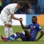  England's Gary Cahill, left, helps Italy's Mario Balotelli to his feet after fouling him during the group D World Cup soccer match between England and Italy at the Arena da Amazonia in Manaus, Brazil, Saturday, June 14, 2014. (AP Photo/Martin Mejia)