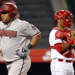 Arizona Diamondbacks' Yasmany Tomas, left, heads to the dugout after hitting a solo home run, with Los Angeles Angels catcher Carlos Perez, right, looking away, during the fifth inning of a baseball game in Anaheim, Calif., Monday, June 15, 2015. (AP Photo/Alex Gallardo)
