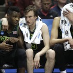 Baylor guard Brady Heslip, center, hugs a teammate as Isaiah Austin wipes his face with towel during the second half against Wisconsin in an NCAA men's college basketball tournament regional semifinal, Thursday, March 27, 2014, in Anaheim, Calif. Wisconsin won 69-52. (AP Photo/Jae C. Hong)