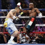 Marcos Maidana, left, from Argentina, drives Floyd Mayweather Jr. against the ropes in the first round of their WBC-WBA welterweight title boxing fight Saturday, May 3, 2014, in Las Vegas. (AP Photo/Eric Jamison)