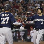 Milwaukee Brewers' Ryan Braun (8) reaches out to shake hands with Carlos Gomez (27) after Braun hit a home run against the Arizona Diamondbacks during the sixth inning of a baseball game Friday, July 24, 2015, in Phoenix. (AP Photo/Ross D. Franklin)