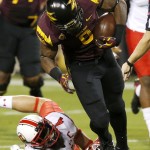 Arizona State's Kalen Ballage, right, breaks the tackle of Utah's Brian Blechen (4) in the first half of an NCAA college football game on Saturday, Nov. 1, 2014, in Tempe, Ariz. (Photo/Ross D. Franklin)