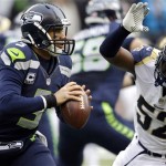  Seattle Seahawks quarterback Russell Wilson (3) passes under pressure from St. Louis Rams outside linebacker Alec Ogletree (52) in the second half of an NFL football game, Sunday, Dec. 29, 2013, in Seattle. The Seahawks won 27-9. (AP Photo/Elaine Thompson)
