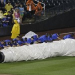 Grounds crew members cover the field during a rain delay of a baseball game between the New York Mets and the Arizona Diamondbacks Tuesday, July 2, 2013, in New York. (AP Photo/Frank Franklin II)