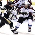 Pittsburgh Penguins' Sidney Crosby (87) battles with Colorado Avalanche Jan Hejda (8) during the first period of an NHL hockey game in Pittsburgh Monday, Oct. 21, 2013. (AP Photo/Gene J. Puskar)
