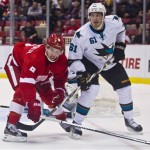 Detroit Red Wings forward Justin Abdelkader (8) and San Jose Sharks forward Tyler Kennedy (81) lock sticks as they follow the puck, during the first period of an NHL hockey game in Detroit, Mich., Monday, Oct. 21, 2013. (AP Photo/Tony Ding)