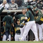 Oakland Athletics' Manny Ramirez is greeted in the dugout after his solo home run against the Arizona Diamondbacks during the third inning of a spring training baseball game, Monday, March 19, 2012, in Phoenix. (AP Photo/Marcio Jose Sanchez)
