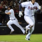 Atlanta Braves' Dan Uggla races home from third to score as Freddie Freeman, right, heads to first, which he reached safely, against the Arizona Diamondbacks during the seventh inning of a baseball game, Tuesday, June 26, 2012, in Atlanta. (AP Photo/John Amis)

