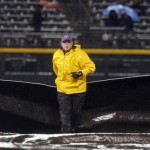 A field guard helps pull the tarpaulin after umpires called a delay for 
rain after the fourth inning of a baseball game betwen the Arizona 
Diamondbacks and the Colorado Rockies in Denver, Saturday, April 14, 
2012. (AP Photo/David Zalubowski)