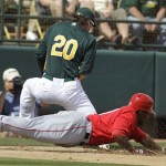 Los Angeles Angels' Howard Kendrick dives back to third base as Oakland Athletics' Josh Donaldson takes a throw during the first inning of a spring training baseball game Monday, March 5, 2012, in Phoenix. (AP Photo/Darron Cummings)