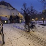 A cyclist steps down from his bike to negotiate a slope on a slippery bridge leading to Amstel Church, a church built around 1670 originally designed to be a wooden preacher's barn, as light snow covers the city center of Amsterdam, Netherlands, Monday Nov. 29, 2010. (AP Photo/Peter Dejong)