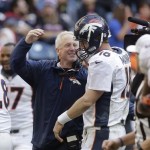 Denver Broncos coach John Fox, left, celebrates with Peyton Manning (18) after Manning threw a touchdown pass during the fourth quarter of an NFL football game against the Houston Texans, Sunday, Dec. 22, 2013, in Houston. (AP Photo/Patric Schneider)