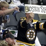 A Boston Bruins fan, right, holds a sign during the third inning in Game 1 of the NHL hockey Stanley Cup Eastern Conference finals between the Boston Bruins and Pittsburgh Penguins in Pittsburgh, Saturday, June 1, 2013. The Bruins won 3-0. (AP Photo/Gene J. Puskar)