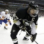 Pittsburgh Penguins' Sidney Crosby (87) digs the puck out of the corner as New York Islanders' Andrew MacDonald (47) watches during the second period of Game 2 of an NHL hockey Stanley Cup first-round playoff series, Friday, May 3, 2013, in Pittsburgh. (AP Photo/Gene J. Puskar)