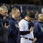 New York Yankees manager Joe Girardi, left, catcher Francisco Cervelli, third from left, and others bow their heads during a moment of silence for victims of the Boston Marathon explosions before a baseball game against the Arizona Diamondbacks at Yankee Stadium in New York, Tuesday, April 16, 2013. (AP Photo/Kathy Willens)