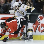 Chicago Blackhawks left wing Viktor Stalberg (25) loses his footing against Boston Bruins defenseman Adam McQuaid (54) in the second period during Game 5 of the NHL hockey Stanley Cup Finals, Saturday, June 22, 2013, in Chicago. (AP Photo/Nam Y. Huh)
