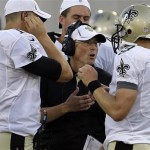 New Orleans Saints offensive coordinator Pete Carmichael. center, 
talks with New Orleans Saints quarterback Drew Brees (9) during the 
first quarter of the NFL Hall of Fame exhibition football game against 
the Arizona Cardinals, Sunday, Aug. 5, 2012 in Canton, Ohio. (AP 
Photo/Gene J. Puskar)
