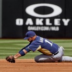Milwaukee Brewers shortstop Alex Gonzalez can't make the diving stop on a base hit by Texas Rangers' Michael Young in the first inning of a spring training baseball game Monday, March 19, 2012, in Surprise, Ariz. (AP Photo/Lenny Ignelzi)