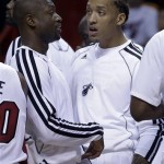 Miami Heat's shooting guard Dwyane Wade, left, talks to teammate Michael Beasley during a timeout in the fourth quarter of an NBA preseason basketball game against the Atlanta Hawks, Monday, Oct. 7, 2013, in Miami. Wade and Beasley did not play in the game. The Heat won 92-87. (AP Photo/Alan Diaz)