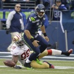  Seattle Seahawks' Russell Wilson (3) fumbles as he is hit by San Francisco 49ers' Aldon Smith (99) during the first half of the NFL football NFC Championship game Sunday, Jan. 19, 2014, in Seattle. (AP Photo/Ted S. Warren)