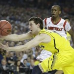 Michigan guard Nik Stauskas (11) vies for a loose ball with Louisville guard Russ Smith (2) during the first half of the NCAA Final Four tournament college basketball championship game Monday, April 8, 2013, in Atlanta. (AP Photo/Charlie Neibergall)
