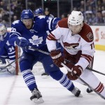  Toronto Maple Leafs' Carl Gunnarsson defends as Phoenix Coyotes' Martin Hanzal (11) controls the puck during the first period of an NHL hockey game action in Toronto on Thursday, Dec. 19, 2013. (AP Photo/The Canadian Press, Frank Gunn)
