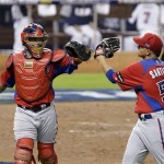 Puerto Rico catcher Yadier Molina, left, and pitcher Mario Santiago congratulate each other at the end of the second inning of a second-round World Baseball Classic game against the United States, Tuesday, March 12, 2013, in Miami. (AP Photo/Wilfredo Lee)