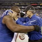 Indianapolis Colts' Cory Redding (90) and Colts head coach Chuck Pagano celebrate after beating Kansas City Chiefs 45-44 at an NFL wild-card playoff football game Saturday, Jan. 4, 2014, in Indianapolis. Indianapolis defeated Kansas City 45-44. (AP Photo/Michael Conroy)