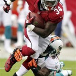 Arizona Cardinals running back Ryan Williams (34) breaks the tackle of Miami Dolphins center Mike Pouncey, right, during the first half of an NFL football game, Sunday, Sept. 30, 2012, in Glendale, Ariz. (AP Photo/Paul Connors)