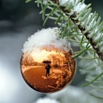 The photographer with an umbrella is reflected in a Christmas bubble in the snow in Gelsenkirchen, western Germany, Monday, Nov. 29, 2010. Winter arrives all over Germany with heavy snowfall and ice.(AP Photo/Martin Meissner)