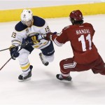  Buffalo Sabres' Cody Hodgson (19) tries to pass the puck as he is hit by Phoenix Coyotes' Martin Hanzal (11), of the Czech Republic, during the second period of an NHL hockey game on Thursday, Jan. 30, 2014, in Glendale, Ariz. (AP Photo)