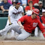 Washington Nationals' Bryce Harper slides across home plate to score during the fifth inning of an exhibition spring training baseball game against the Atlanta Braves, Tuesday, Feb. 26, 2013, in Kissimmee, Fla. (AP Photo/David J. Phillip)