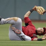 Arizona Diamondbacks left fielder Gerardo Parra tumbles in the outfield after a diving catch on a pop fly by Oakland Athletics' Kurt Suzuki during the third inning of a spring training baseball game Monday, March 19, 2012, in Phoenix. (AP Photo/Marcio Jose Sanchez)