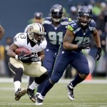 New Orleans Saints running back Darren Sproles, left, runs past Seattle Seahawks defensive end Michael Bennett during the first quarter of an NFC divisional playoff NFL football game in Seattle, Saturday, Jan. 11, 2014. (AP Photo/Elaine Thompson)