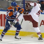  Phoenix Coyotes' Derek Morris, right, is checked by Edmonton Oilers' David Perron (57) during the first period of an NHL hockey game in Edmonton, Alberta, on Tuesday, Dec. 3, 2013. (AP Photo/The Canadian Press, Jason Franson)