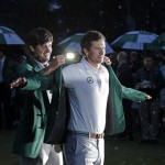 Bubba Watson, left, helps Adam Scott, of Australia, put on his green jacket after winning the Masters golf tournament Sunday, April 14, 2013, in Augusta, Ga. (AP Photo/Charlie Riedel)
