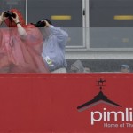 A spectator wears a poncho as rain falls during a horse race at Pimlico Race Course in Baltimore, Saturday, May 18, 2013, before the 138th running of the Preakness Stakes horse race. (AP Photo/Patrick Semansky)
