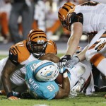 Miami Dolphins defensive end Cameron Wake (91) recovers a fumble by Cincinnati Bengals quarterback Andy Dalton, between Bengals tackle Andre Smith (71) and guard Kevin Zeitler (68) during the first half of an NFL football game, Thursday, Oct. 31, 2013, in Miami Gardens, Fla. (AP Photo/Wilfredo Lee)