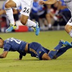 Los Angeles Galaxy defender A.J. DeLaGarza falls at Real Madrid forward Carlos Henrique Casemiro (26) and Daniel Carajal leap over him during the second half of the International Champions Cup soccer match, Thursday, Aug. 1, 2013, in Glendale, Ariz. Real Madrid won 3-1. (AP Photo/Matt York)