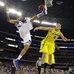 Kansas' Travis Releford is fouled by Michigan's Mitch McGary (4) during the second half of a regional semifinal game in the NCAA college basketball tournament, Friday, March 29, 2013, in Arlington, Texas. (AP Photo/Tony Gutierrez)