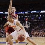Syracuse guard Brandon Triche (20) drives against Wisconsin guard Josh Gasser (21) in the first half of an East Regional semifinal game in the NCAA men's college basketball tournament, Thursday, March 22, 2012, in Boston. (AP Photo/Elise Amendola)