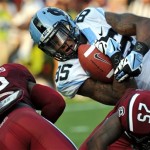North Carolina tight end Eric Ebron (85) is tackled after a reception by South Carolina's Kadetrix Marcus (25) and Brison Williams (12) during the first half of an NCAA college football game, Thursday, Aug. 29, 2013, in Columbia, S.C. (AP Photo/Stephen Morton)