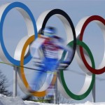 In this photo taken with slow shutter speed athletes pass by the Olympic rings during the men's 50K cross-country race at the 2014 Winter Olympics, Sunday, Feb. 23, 2014, in Krasnaya Polyana, Russia. (AP Photo/Dmitry Lovetsky)