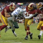 Dallas Cowboys wide receiver Dez Bryant is knocked up of bounds short of the goal line by Washington Redskins outside linebacker Ryan Kerrigan, left, strong safety Brandon Meriweather (31) and free safety E.J. Biggers (30) during the second half of an NFL football game in Landover, Md., Sunday, Dec. 22, 2013. The Cowboys defeated the Redskins 24-23. (AP Photo/Evan Vucci)
