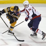 Boston Bruins left wing Brad Marchand (63) tries to skate around Washington Capitals defenseman John Carlson (74) during the first period of Game 1 of an NHL hockey Stanley Cup first-round playoff series in Boston, Thursday, April 12, 2012. (AP Photo/Charles Krupa)