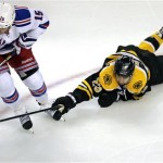 Boston Bruins center Chris Kelly, right, dives as he tries to knock the puck away from New York Rangers right wing Derek Dorsett (15) during the first period in Game 1 of an NHL hockey playoffs Eastern Conference semifinal game in Boston, Thursday, May 16, 2013. (AP Photo/Charles Krupa)