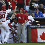 Canada's Michael Saunders (20) celebrates his home run against the United States with coach Denis Boucher, left, and a batboy in the second inning of a World Baseball Classic baseball game on Sunday, March 10, 2013, in Phoenix. (AP Photo/Ross D. Franklin)