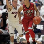 UNLV's Kendall Smith (15) dribbles away from Arizona's T.J. McConnell (4) in the first half of an NCAA college basketball game on Saturday, Dec. 7, 2013, in Tucson, Ariz. (AP Photo/John MIller)
